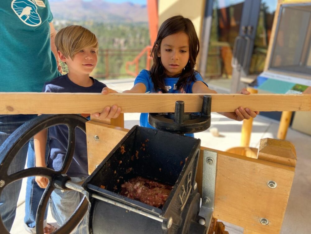 kids with apple cider press at PEECnic 2024